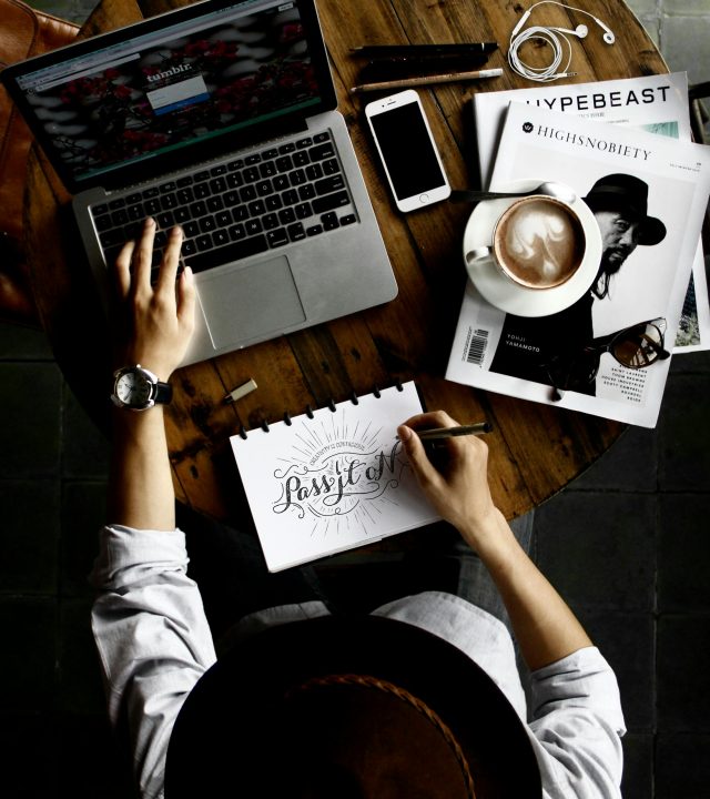 Person Sitting Facing Laptop Computer With Sketch Pad